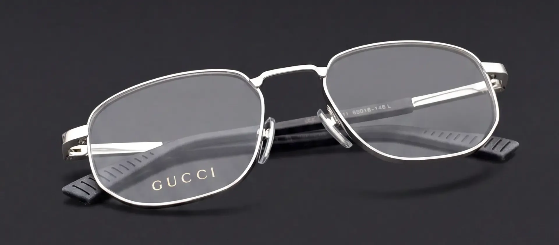 Ochelari Gucci cu ramă argintie, pliați, cu inscripția Gucci pe lentilă