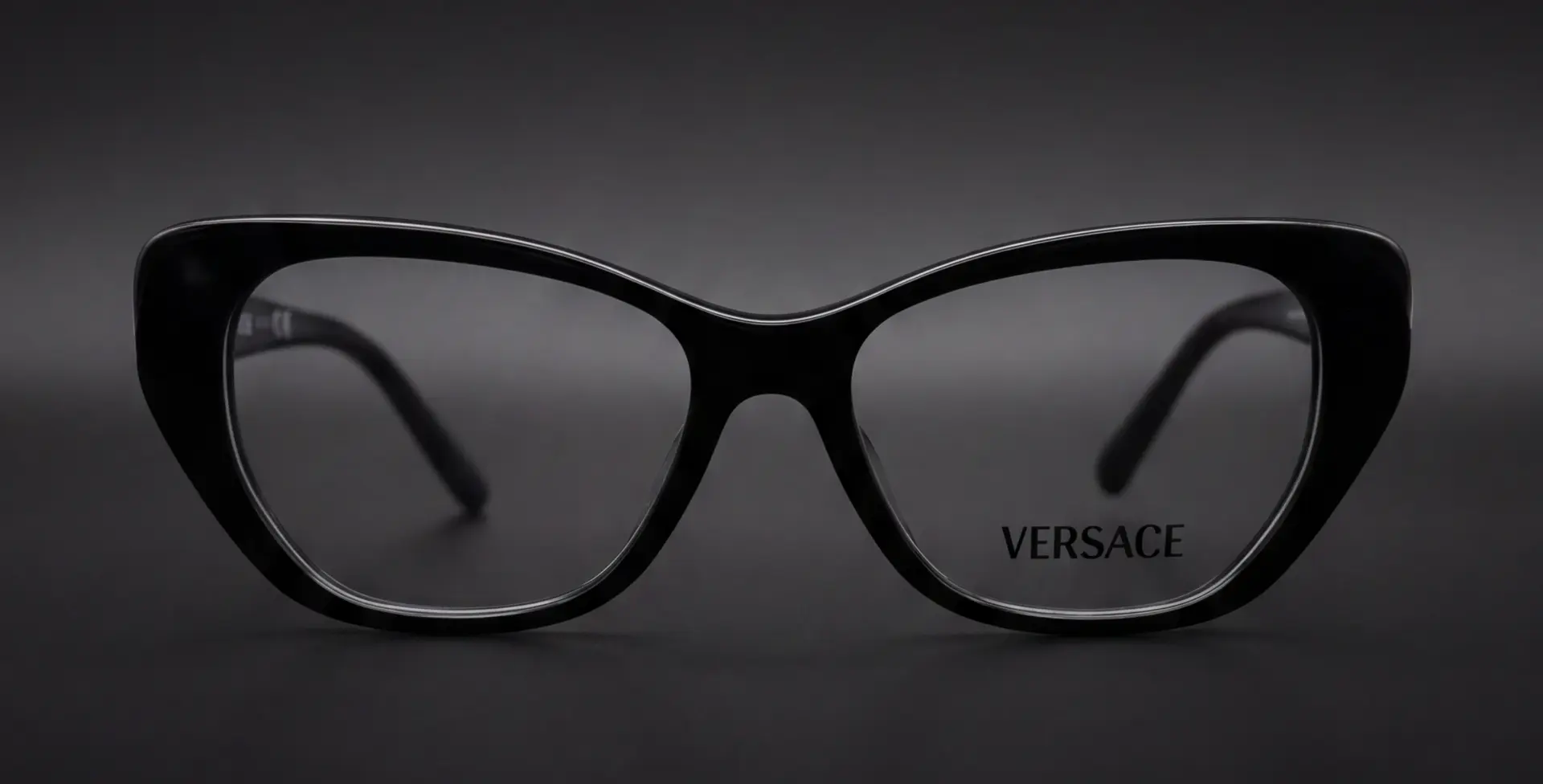 Ramă Versace cat-eye neagră, vedere frontală cu logo Versace pe lentilă, disponibilă la ArenaMed Optics