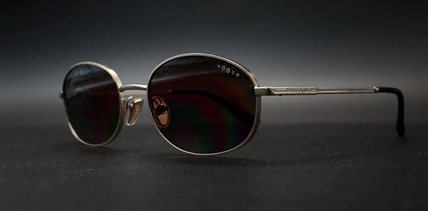 Ramă Vogue ovală aurie cu lentile degradé, vedere semi-profil, disponibilă la ArenaMed Optics