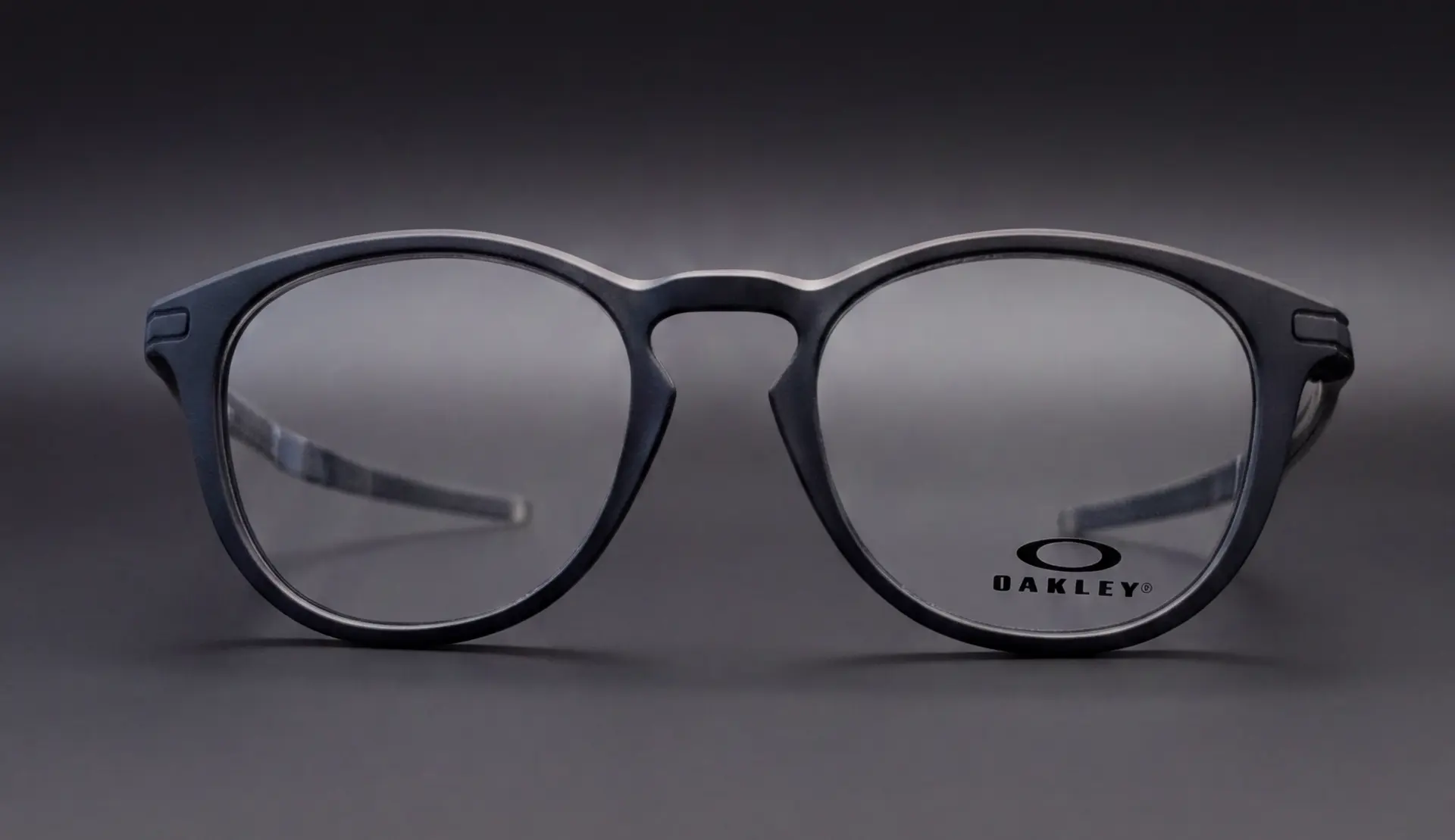 Ramă Oakley Pitchman R albastru mat, vedere frontală rotundă cu logo Oakley pe lentilă