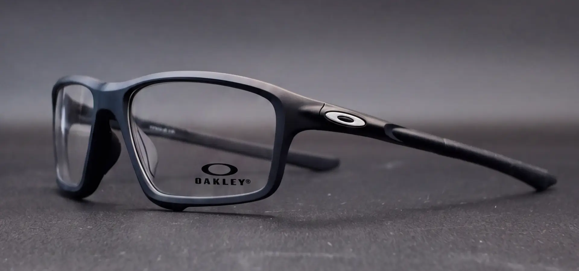 Ramă Oakley Crosslink negru mat văzută din profil, cu logo Oakley pe braț, disponibilă la ArenaMed Optics