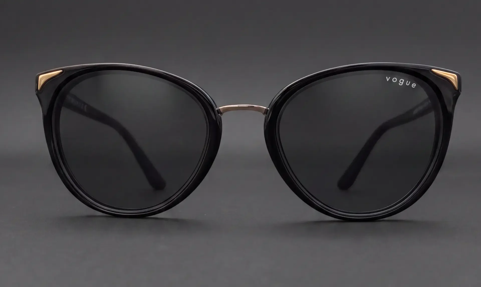 Ochelari de soare Vogue cat-eye negri cu accente aurii, vedere frontală, disponibili la ArenaMed Optics