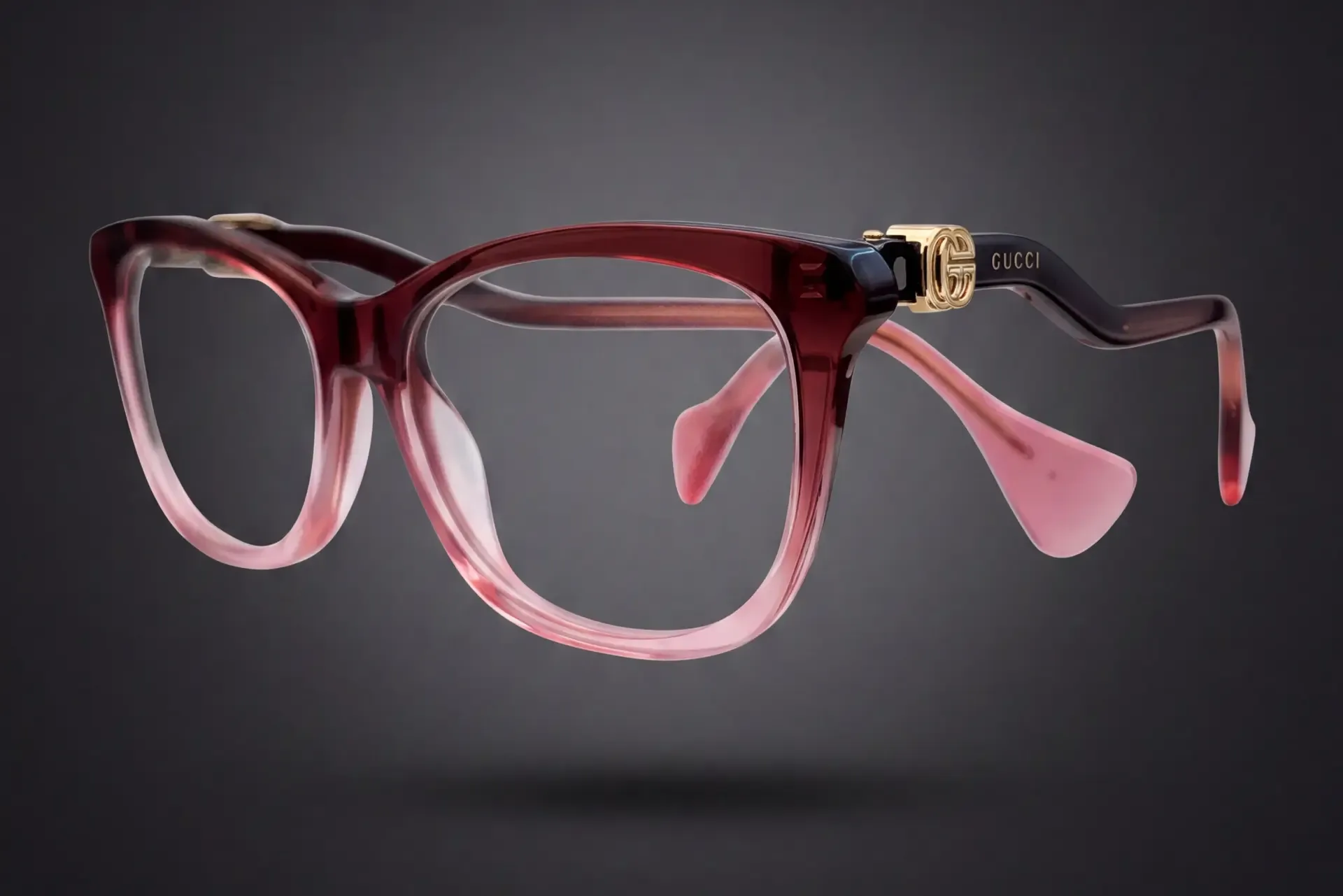 Ramă Gucci bordo-roz degradé văzută din profil, cu logo GG auriu pe braț, disponibilă la ArenaMed Optics