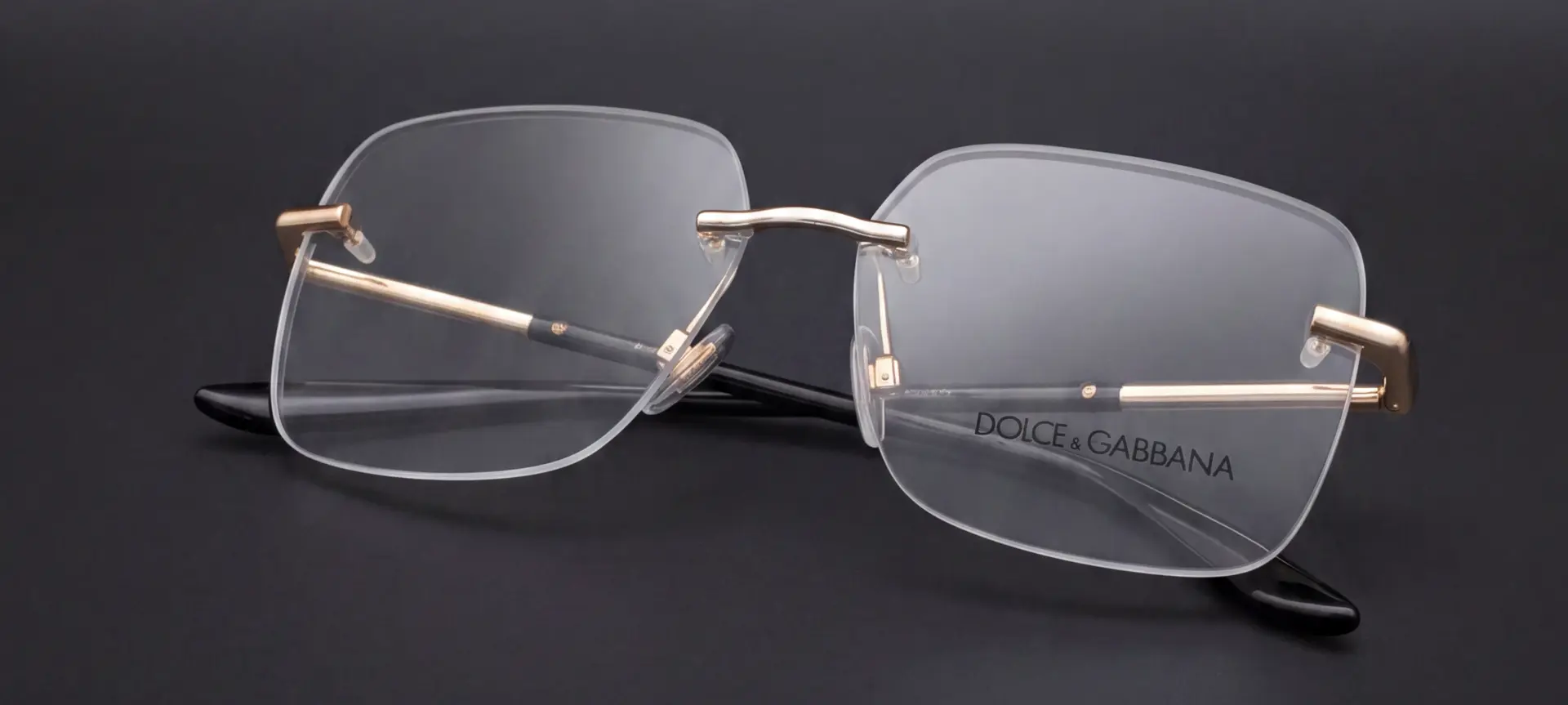 Ochelari Dolce & Gabbana rimless pliați, cu inscripția Dolce & Gabbana pe lentilă