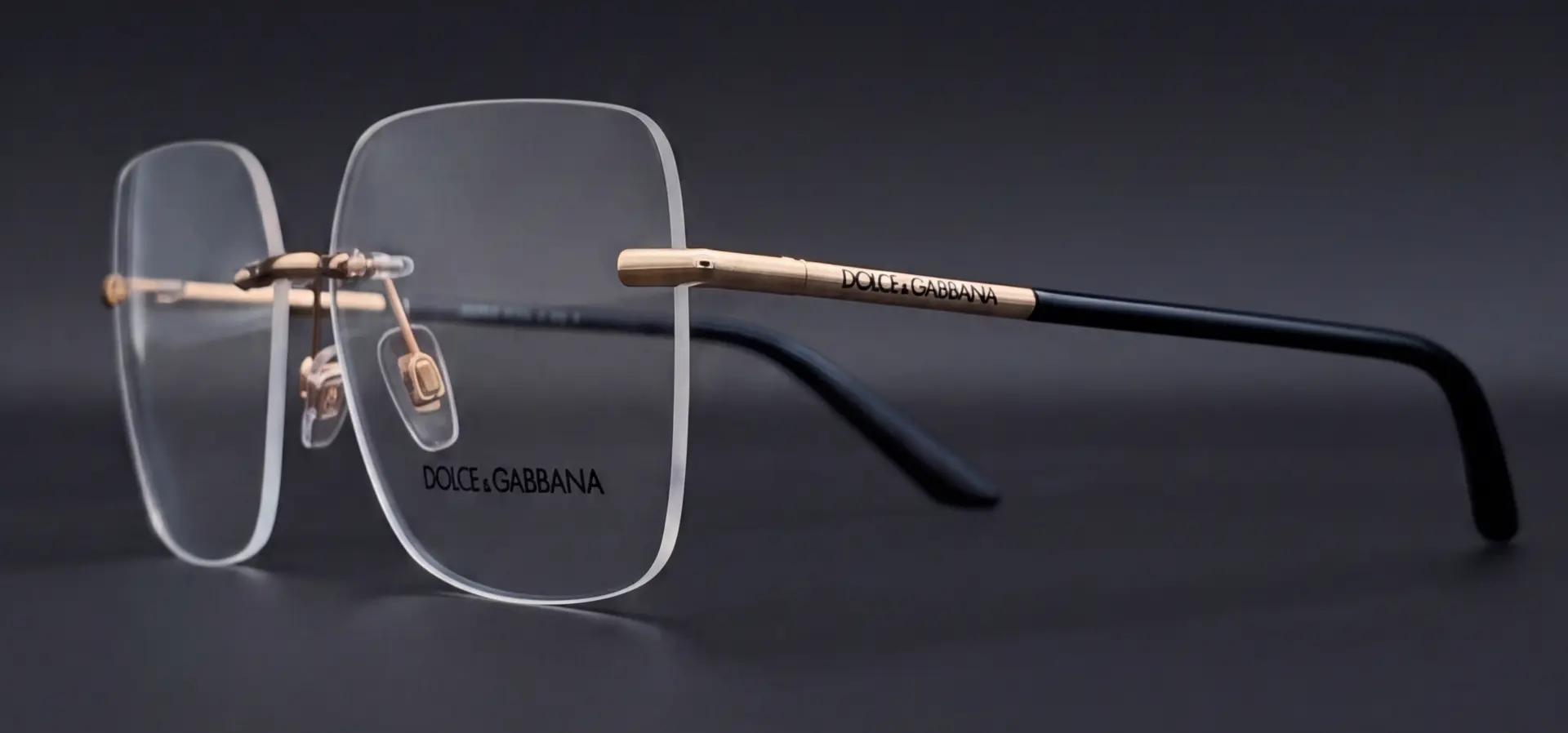 Ramă Dolce & Gabbana rimless văzută din profil, braț auriu cu logo